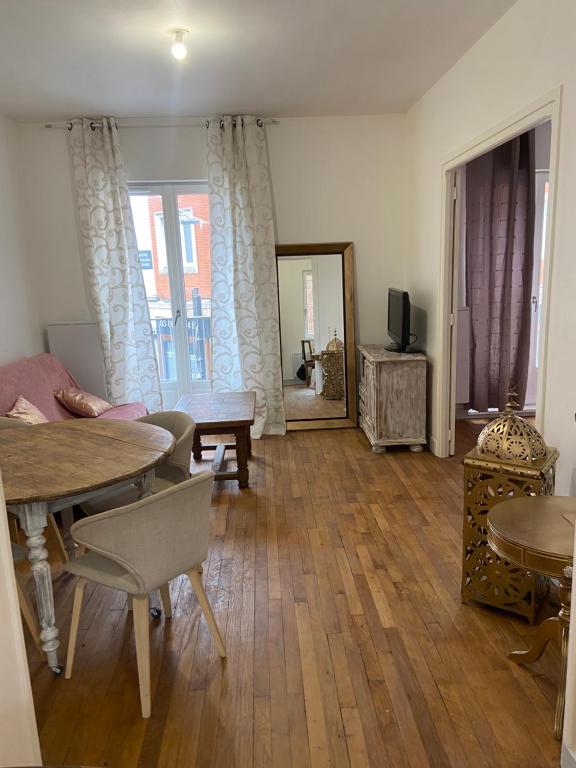 - un salon avec une table, des chaises et un miroir dans l'établissement Iago city, à Beauvais