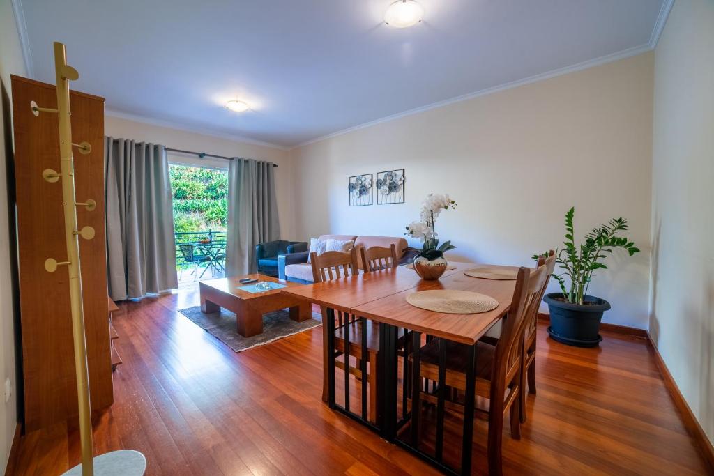 a dining room and living room with a table and chairs at TMaria in Ponta do Sol