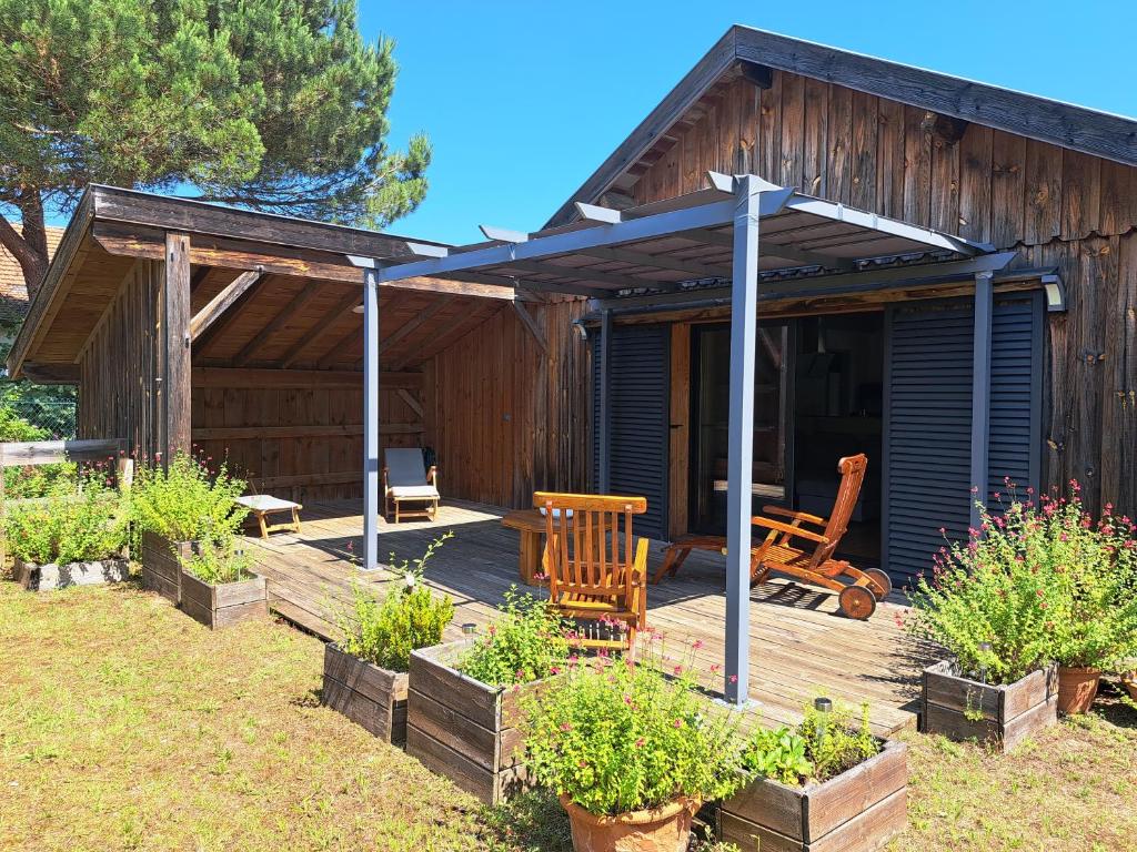 une maison dotée d'une terrasse en bois avec une table et des chaises dans l'établissement La Canopée, à Lit-et-Mixe