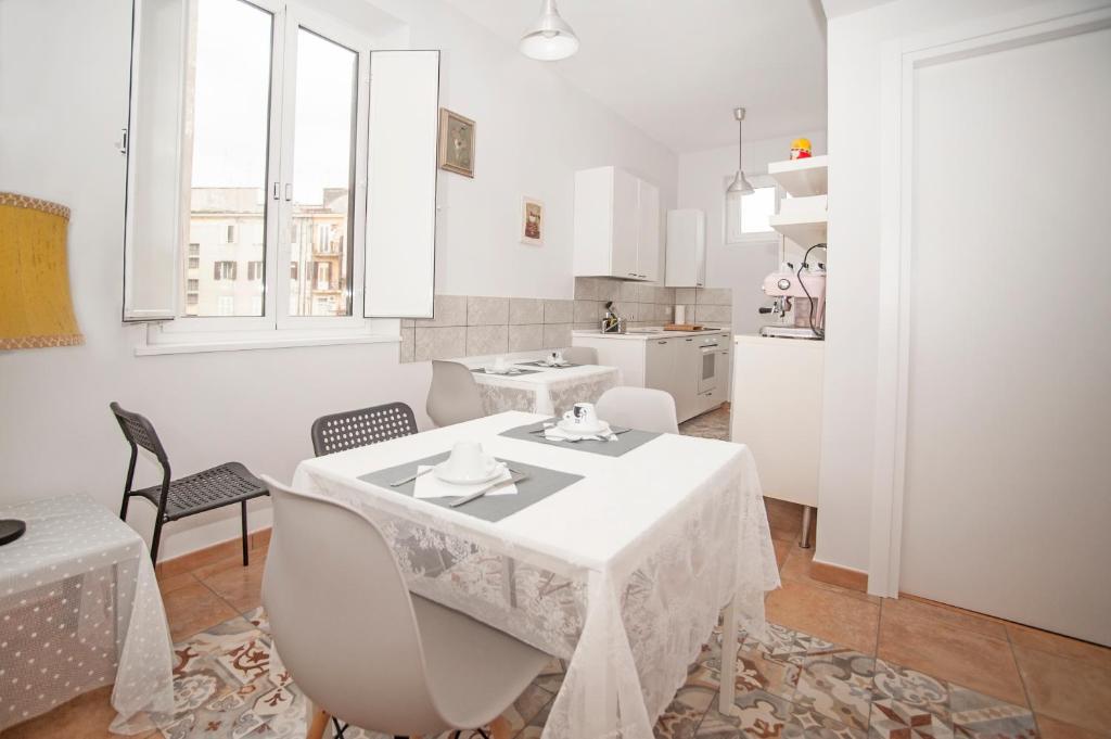 a white room with a table and chairs and a kitchen at GuestHouse Martin in Rome