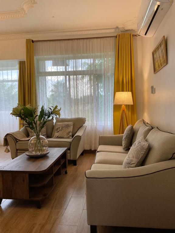Una sala de estar con dos sofás y una mesa. en Amala villas, en Arusha