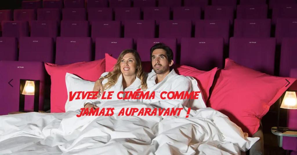 a man and a woman laying in bed with a sign at AV de Bordeaux in Narbonne