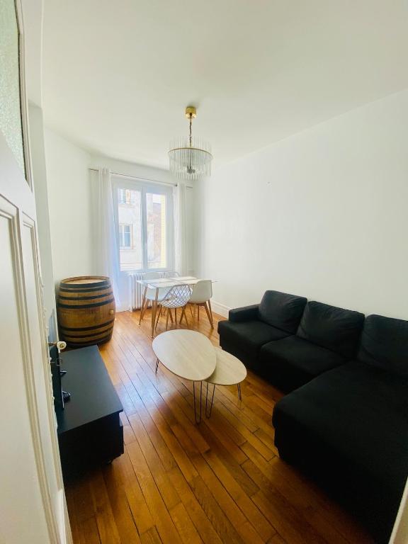 un salon avec un canapé noir et une table dans l'établissement Dijon Centre ville Gare Parc Darcy, à Dijon