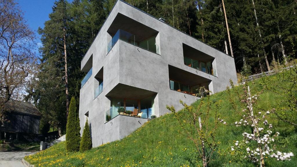 un edificio en la cima de una colina con árboles en Alpin Lodge St. Andrä, en Bresanona