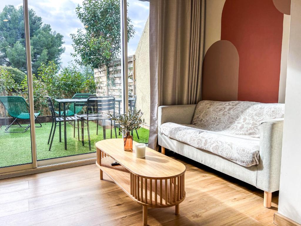un salon avec un canapé et une table dans l'établissement Appartement Evasion Ensoleillée - Parking Jardin, à La Ciotat