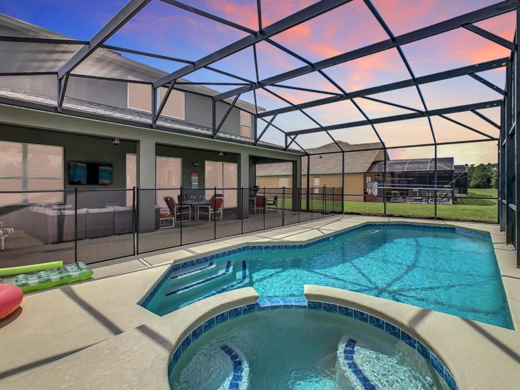 ein großes Schwimmbad mit Glasdach in der Unterkunft 7BR Villa in Emerald Island w/ Resort Perks in Kissimmee