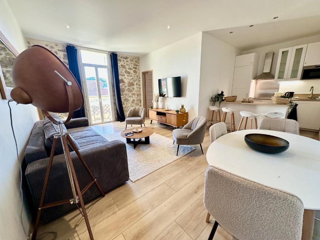 un salon avec un canapé et une table avec des chaises dans l'établissement Gorgeous 2 bedrooms brand new 3 Avenue Paul Arène, à Antibes