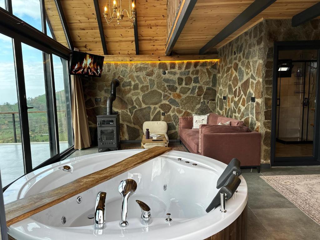 a large bath tub in a room with windows at ARTE SUİT Bungalov in Ardeşen