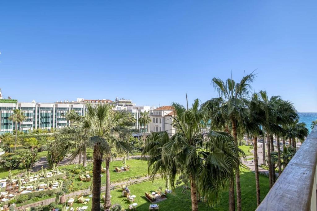 - une vue depuis le balcon d'un complexe avec des palmiers dans l'établissement REF 1512 - Cannes Croisette, à Cannes