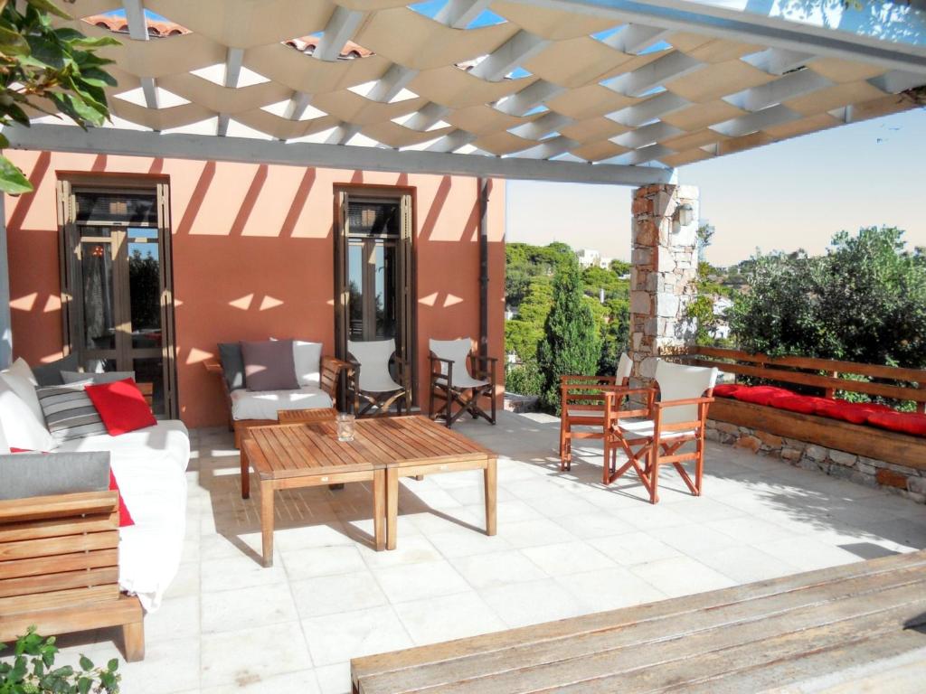 a patio with a wooden table and chairs at Charming house with sea view in Chrousa, fenced garden in Chrousa