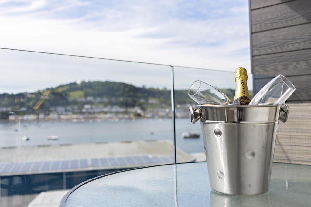 einen Eimer mit einer Champagnerflasche auf dem Tisch in der Unterkunft Teign View, Grand Banks in Teignmouth