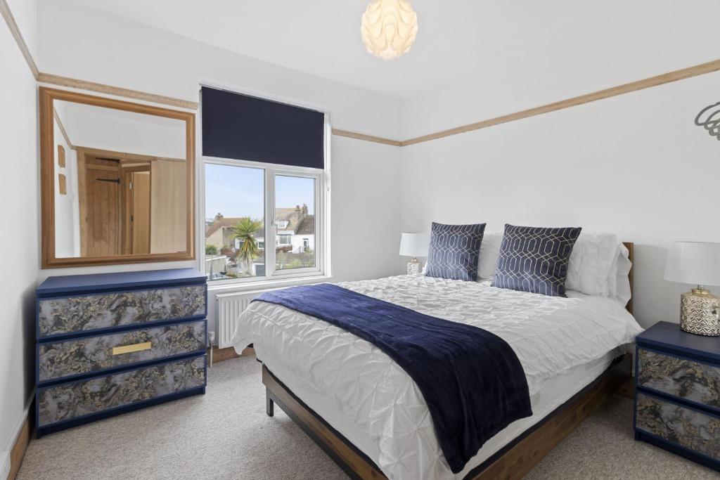 a bedroom with a large bed and a mirror at Seaway Garden, Beachside Maisonette with Parking in Paignton