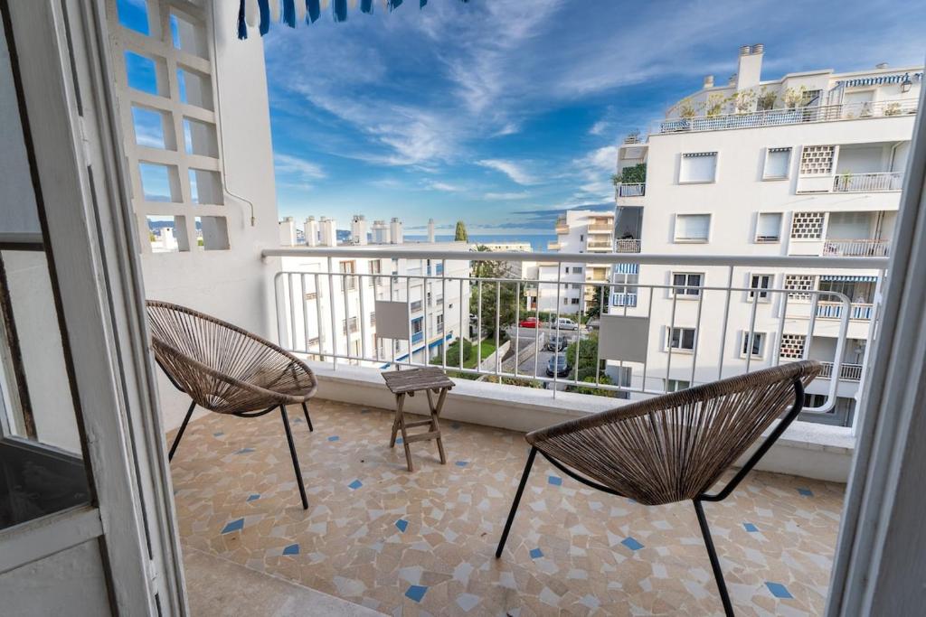 - deux chaises sur un balcon avec vue sur un bâtiment dans l'établissement Il Sole e Mare, à Nice
