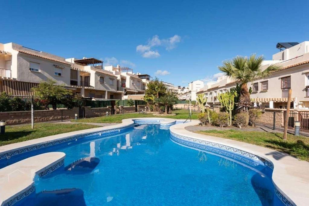 a swimming pool with blue water in a resort at Holidays Urban Home in Caserío Almayate Bajo