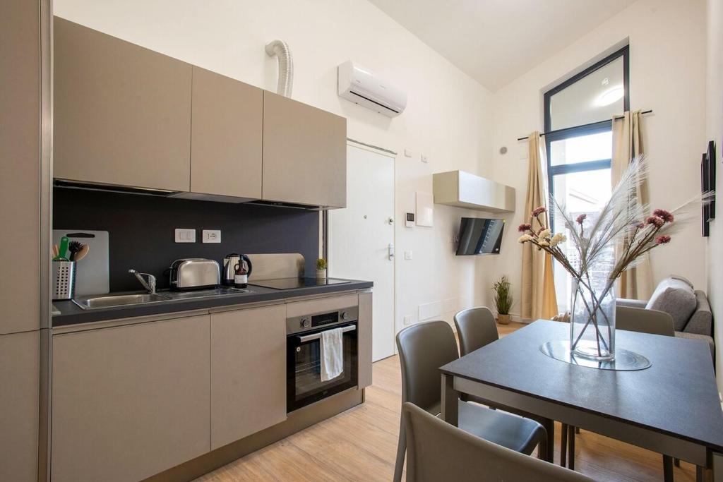 a kitchen and dining room with a table in a room at Urban Oasis near Termini, Free Parking&Balcony, int10 in Rome