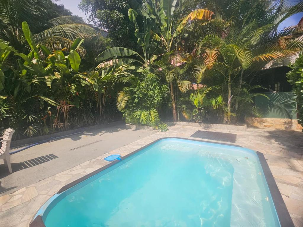 a swimming pool in a yard with palm trees at Hospedaria do Engenho in Niterói