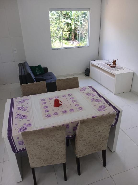 einen Esstisch mit einem lila und weißen Tischtuch in der Unterkunft Casa de Campo in Governador Celso Ramos