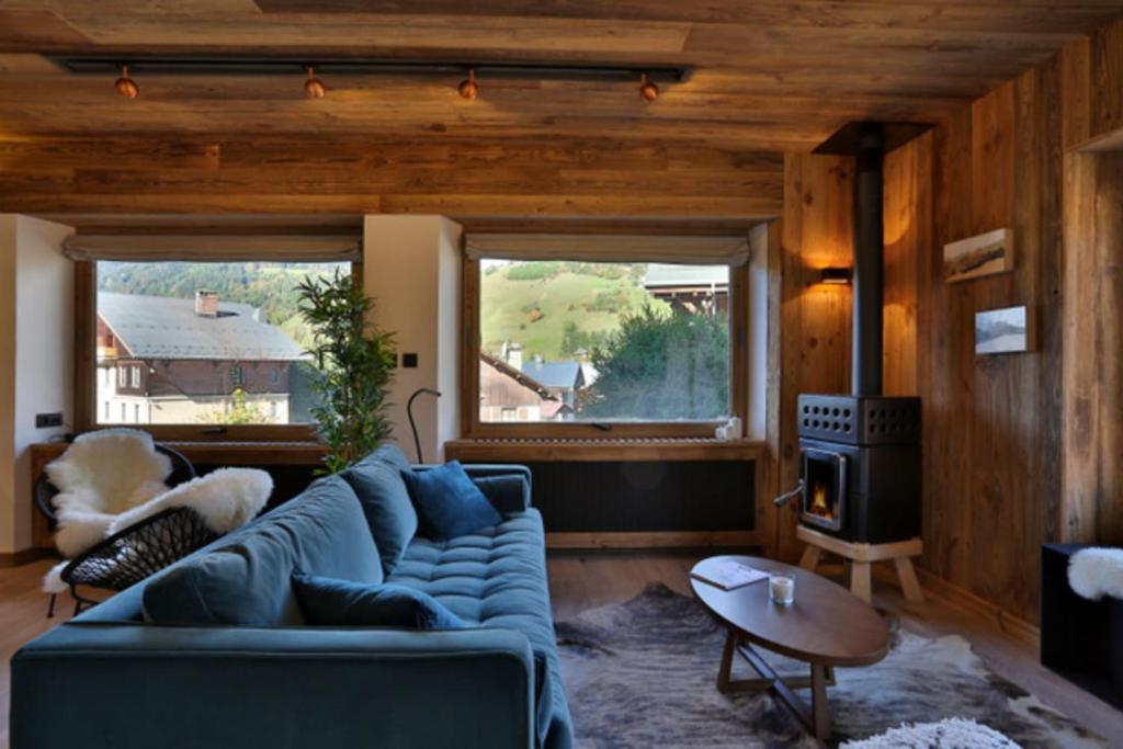 un salon avec un canapé bleu et une cheminée dans l'établissement Spacious T3 with balcony in the center of town, à Megève