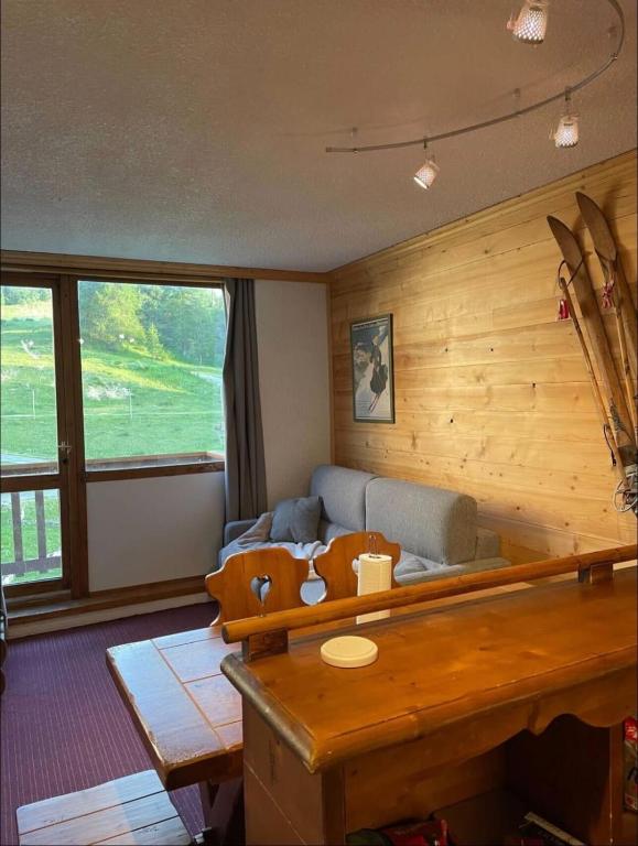 un salon avec un canapé et une table dans l'établissement Charming T2 close to the slopes of La Plagne, à La Plagne Tarentaise