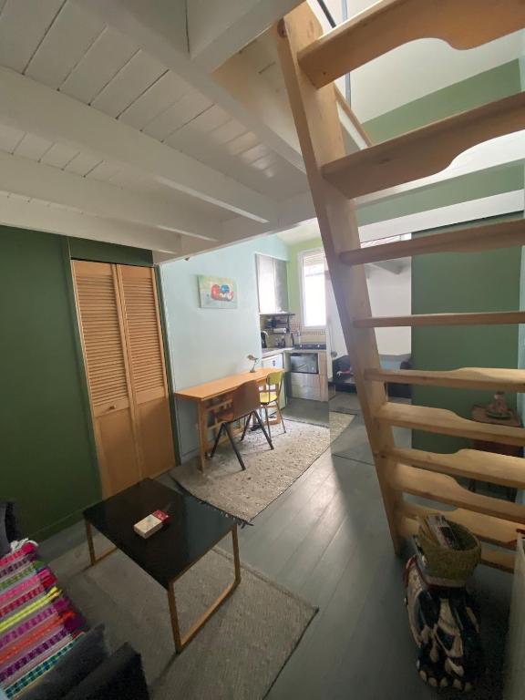 - un salon avec une mezzanine et une table dans l'établissement Paris 19 Studio mezzanine,calme,ensoleillé, à Paris