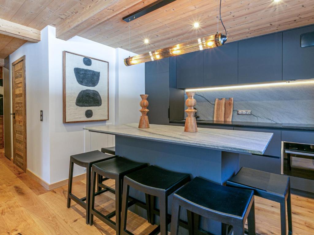 une cuisine avec des placards bleus et des tabourets noirs dans l'établissement Appartement haut de gamme, 4 pers, wifi - FR-1-694-370, à Val dʼIsère