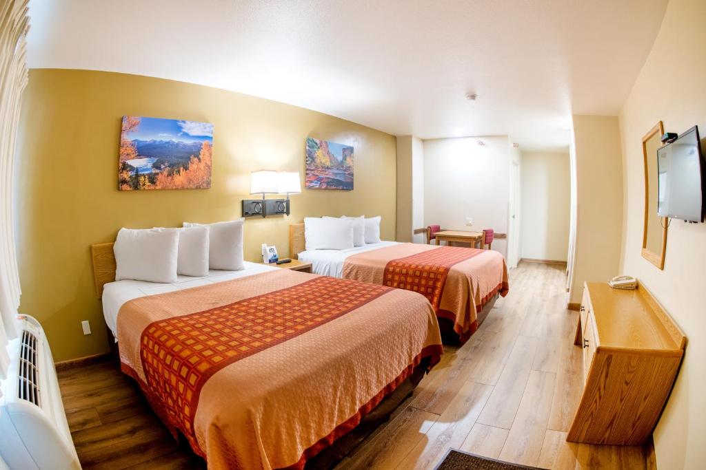 a hotel room with two beds and a flat screen tv at Glenwood Springs Cedar Lodge in Glenwood Springs