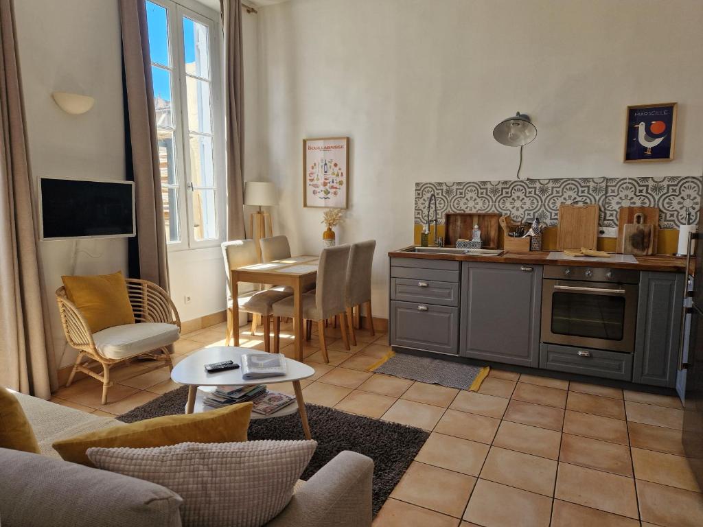un salon avec une cuisine et une table dans l'établissement Superbe 2 pièces avec grande terrasse, classé ***, à Marseille