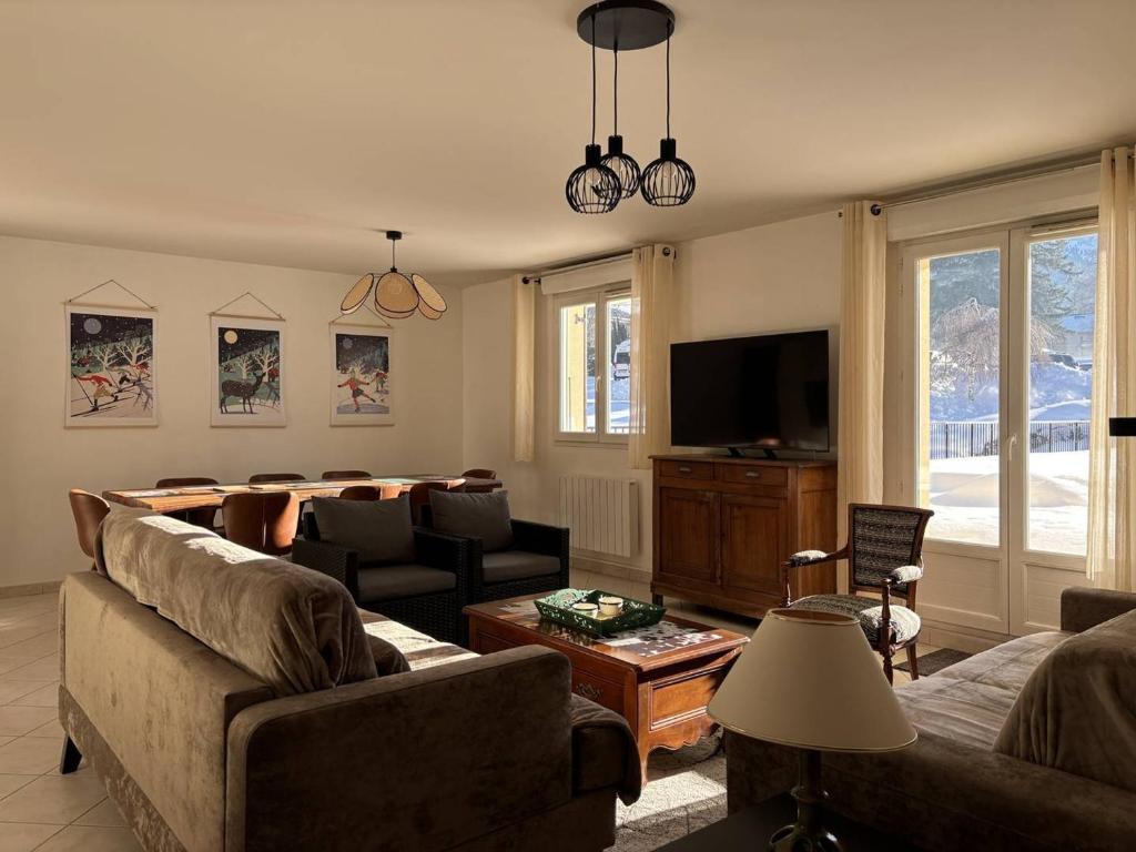 a living room with a couch and a television at Appartement au cœur de Villard de Lans avec grande terrasse et double garage - FR-1-548-47 in Villard-de-Lans