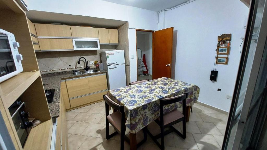 a small kitchen with a table and a refrigerator at Departamento 11 - Av 1 - Grupo DEL SALVADOR in Las Toninas