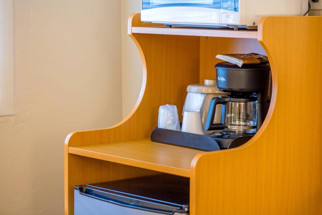 a wooden shelf with a coffee maker on it at Glenwood Springs Cedar Lodge in Glenwood Springs