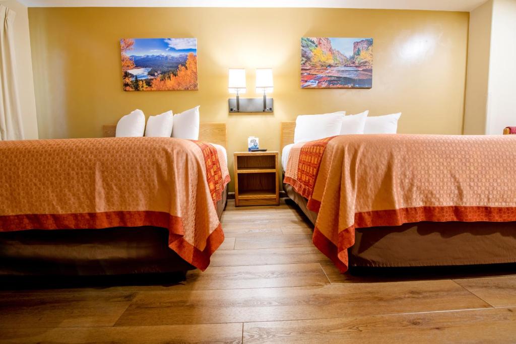 a hotel room with two beds and a wooden floor at Glenwood Springs Cedar Lodge in Glenwood Springs