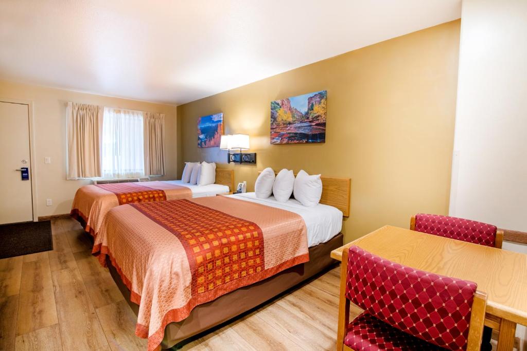 a hotel room with two beds and two chairs at Glenwood Springs Cedar Lodge in Glenwood Springs