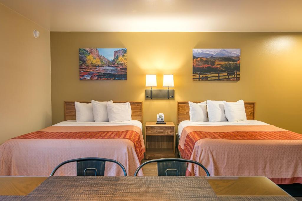 a hotel room with two beds and a table at Glenwood Springs Cedar Lodge in Glenwood Springs