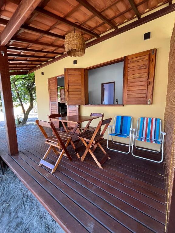 a wooden deck with a table and chairs on it at Casa Umbuê 01 - Vista Mar in Cayru