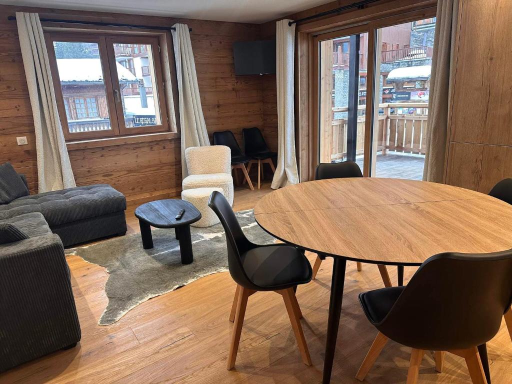 un salon avec une table et des chaises dans l'établissement Appartement cozy 3P à 5m du front de neige avec parking et terrasse - FR-1-464-236, à Pralognan-la-Vanoise