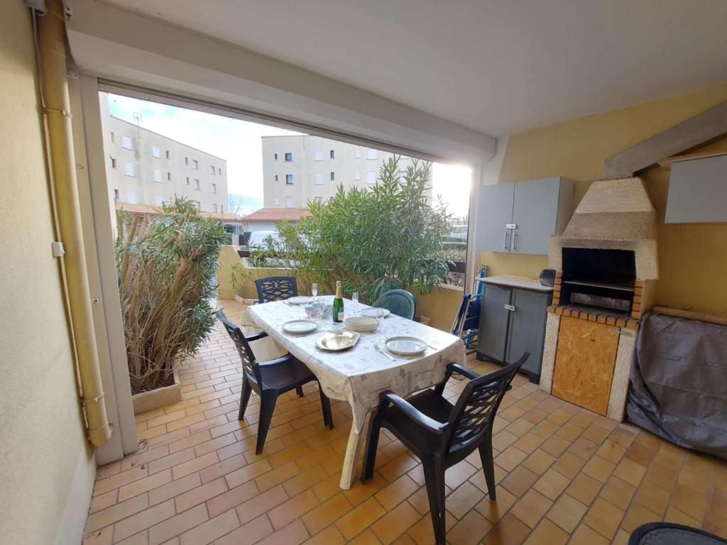 une cuisine avec une table et des chaises sur une terrasse dans l'établissement Confortable 2 pièces cabine, 6 pers, parking à Marseillan-Plage - FR-1-326-839, à Marseillan