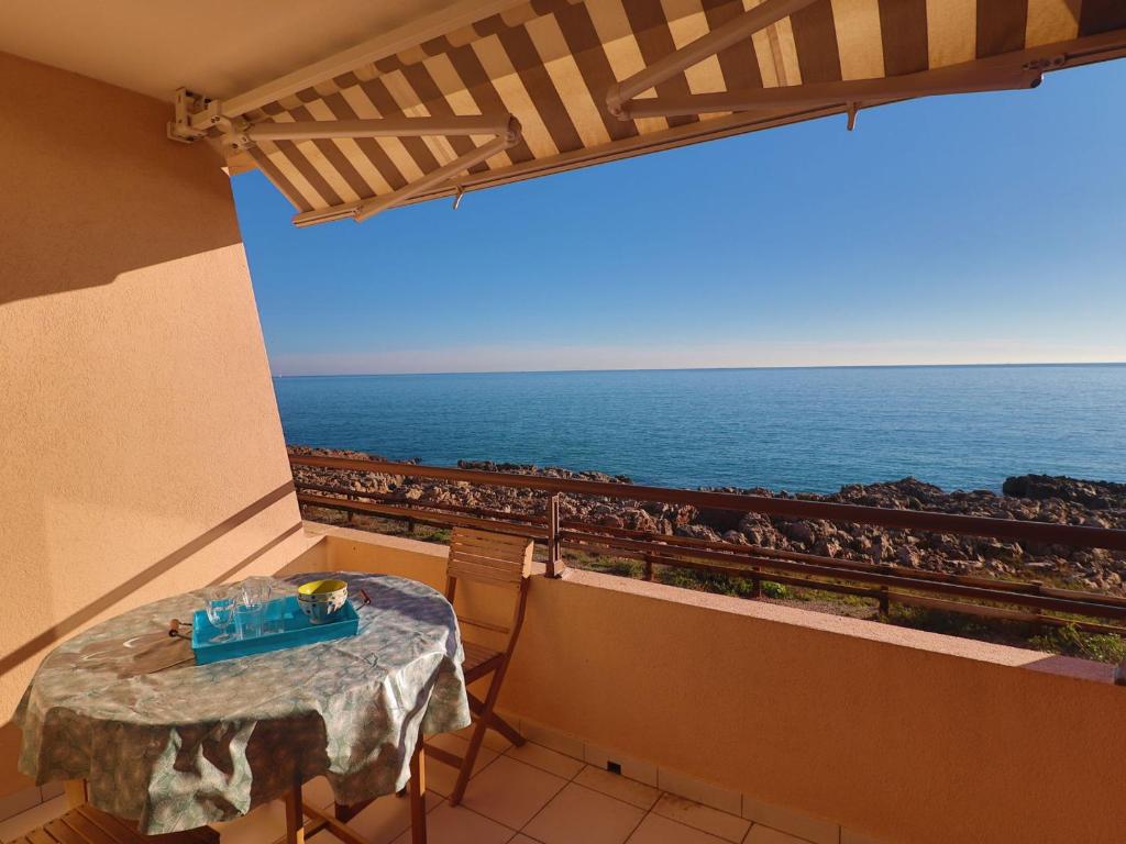 - une table sur un balcon avec vue sur l'océan dans l'établissement T2 avec WIFI, 1ère ligne mer, terrasse, parking - FR-1-472A-310, à Sète