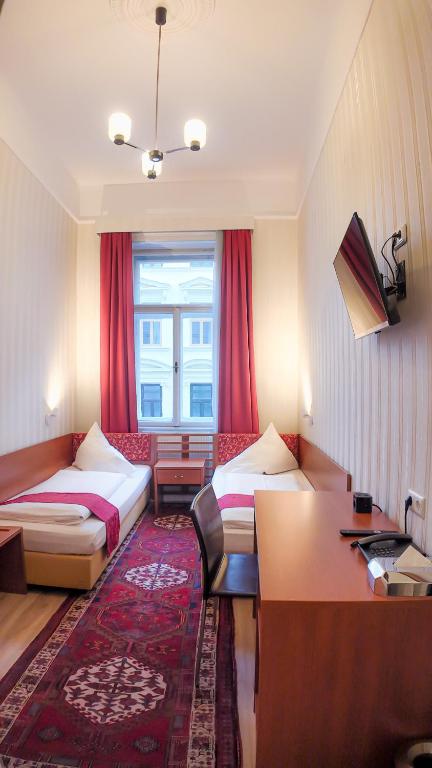 Una habitación de hotel con dos camas y un escritorio. en HPA Hotel Andreas, en Viena