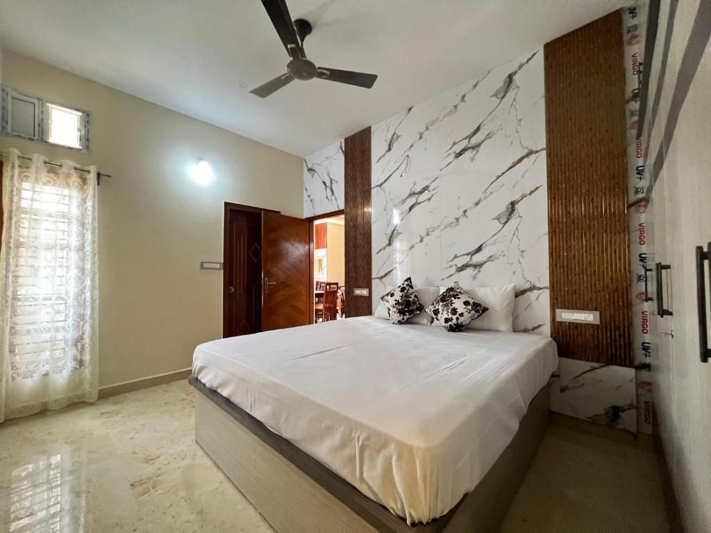 a bedroom with a bed and a marble wall at Western Royal Homes in Bengaluru