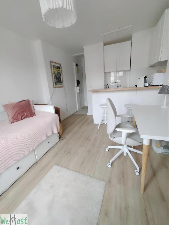 une chambre avec un lit et une table et une cuisine dans l'établissement Paroisse - CI - Versailles Le Cocon, nid douillet à deux pas du Château, à Versailles