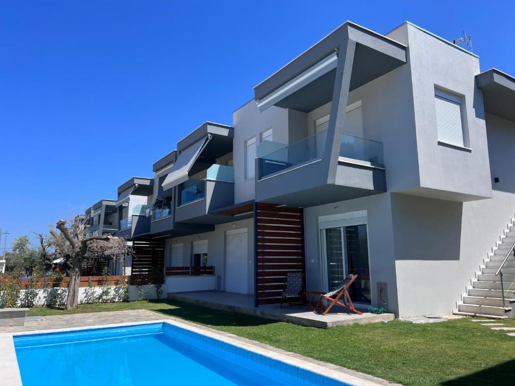 a house with a swimming pool in front of it at Emerald Luxury Apartments in Limenas