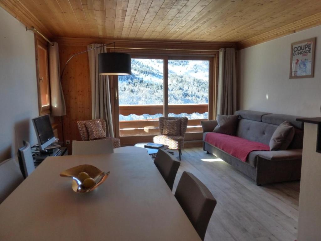 un soggiorno con un tavolo e un divano di Bel appartement 3 pièces rénové - Méribel, 6 pers, Wi-Fi, garage - FR-1-411-976 a Les Allues