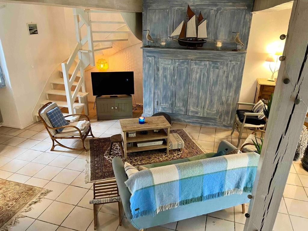 un salon avec un canapé et une télévision dans l'établissement Maison de famille en bord de mer, à Saint-Gildas-de-Rhuys