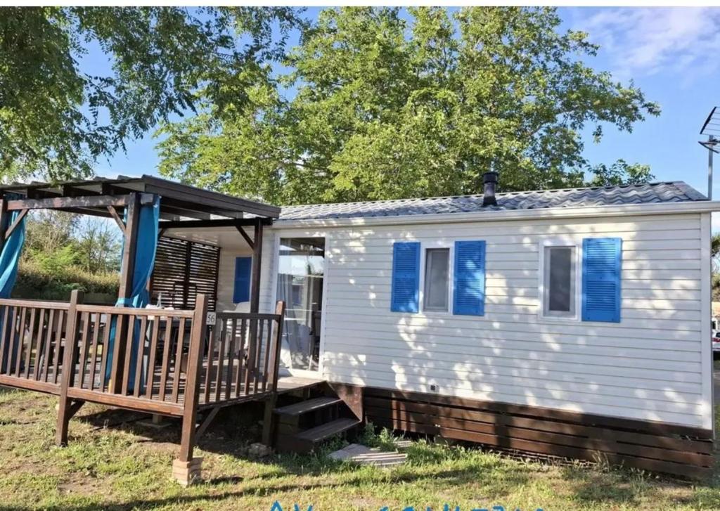 une petite maison avec une terrasse couverte et une balançoire dans l'établissement Bungalow tranquille à Marseillan avec terrasse 32 m², à Marseillan