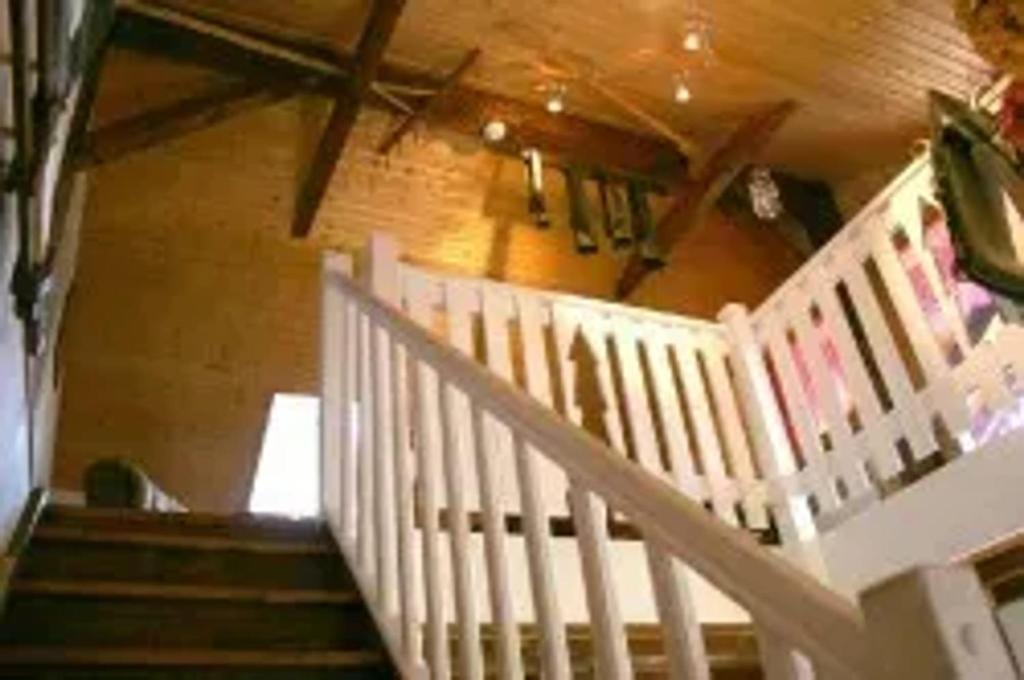 a staircase in a house with a white railing at Chalet spacieux avec jardin à La Longeville in La Longeville