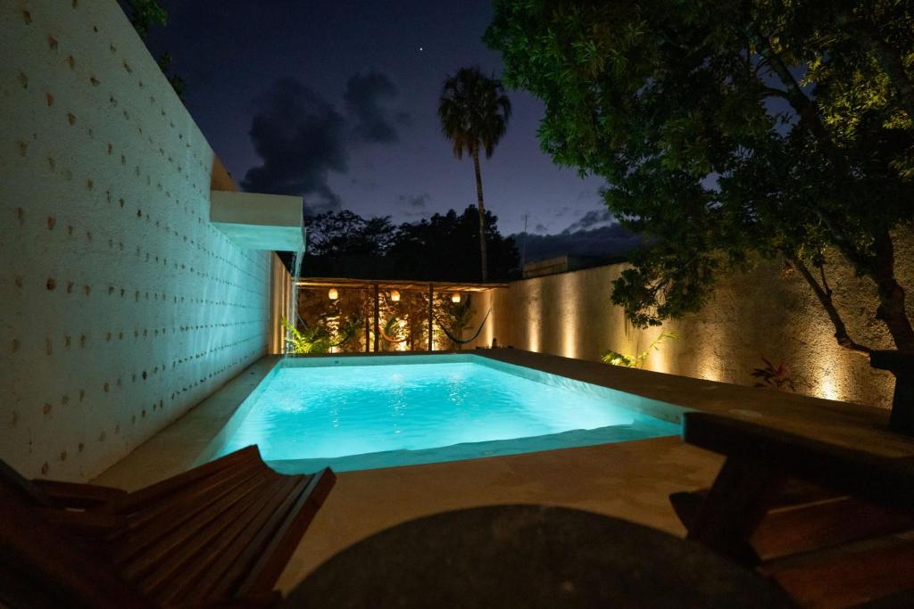 Una piscina en un patio trasero por la noche. en Wild Valladolid 3br Oasis W Pool & Yoga Palapa, en Valladolid