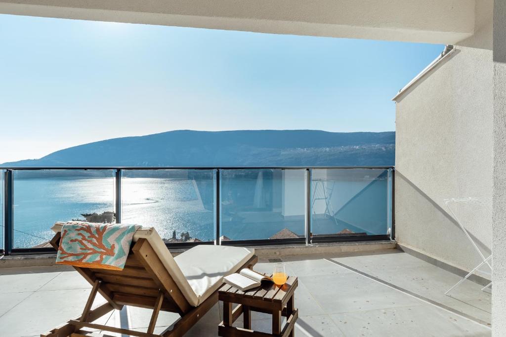 a balcony with a chair and a view of the ocean at Novi Hills Residence in Španjola