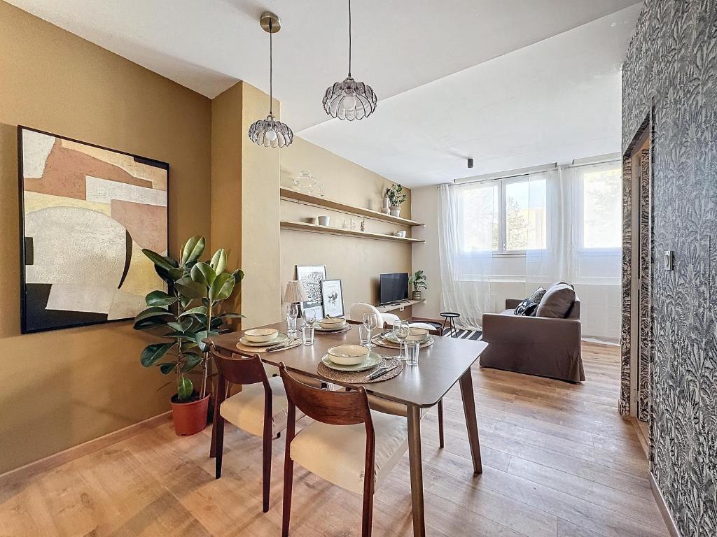 a dining room and living room with a table and chairs at Le pétillant champenois in Reims