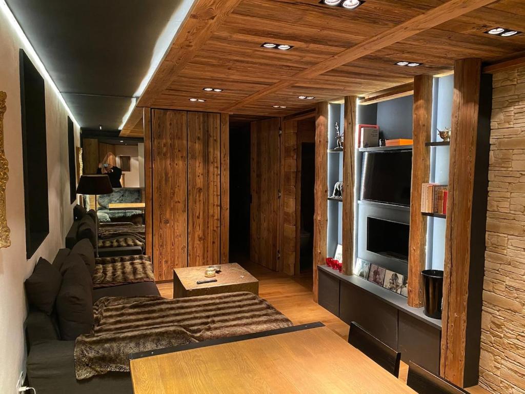- un salon avec des murs lambrissés et un canapé dans l'établissement Appartement 1er Coeur de megeve, à Megève