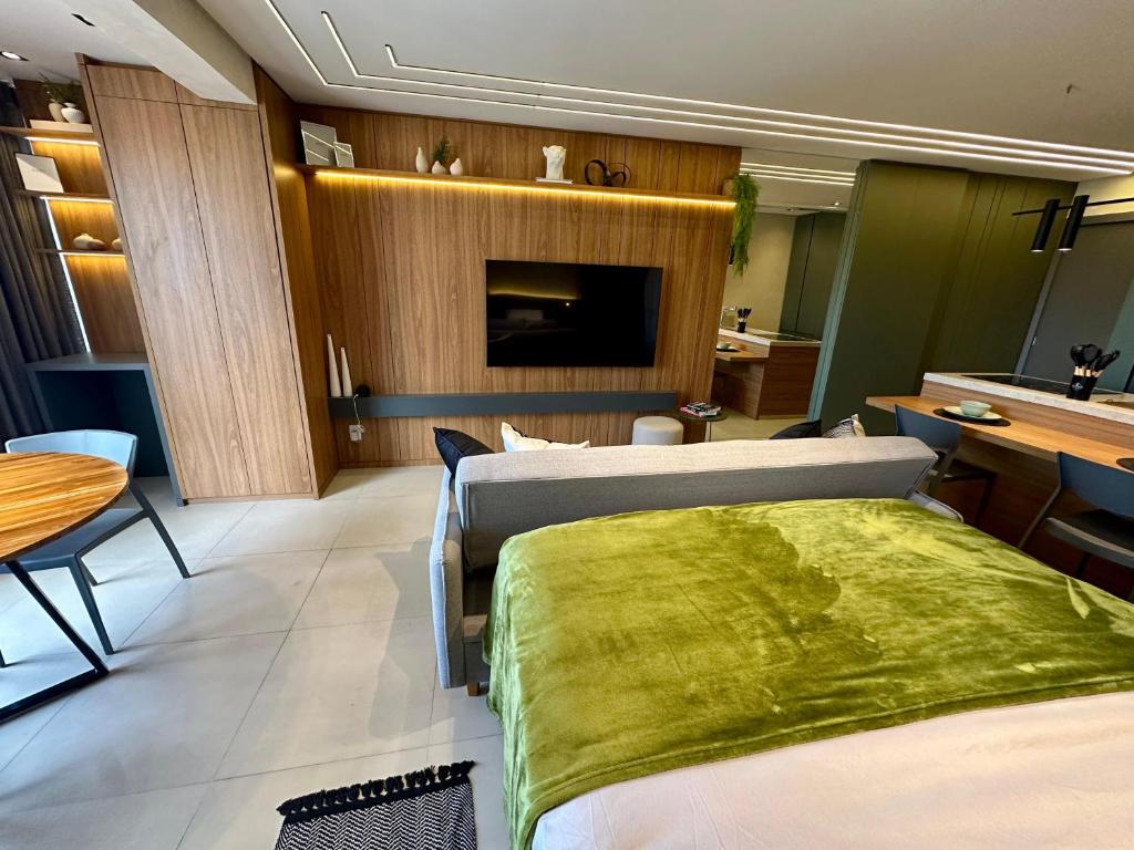 a hotel room with two beds and a television at Studio novo e elegante em Campo Grande in Campo Grande